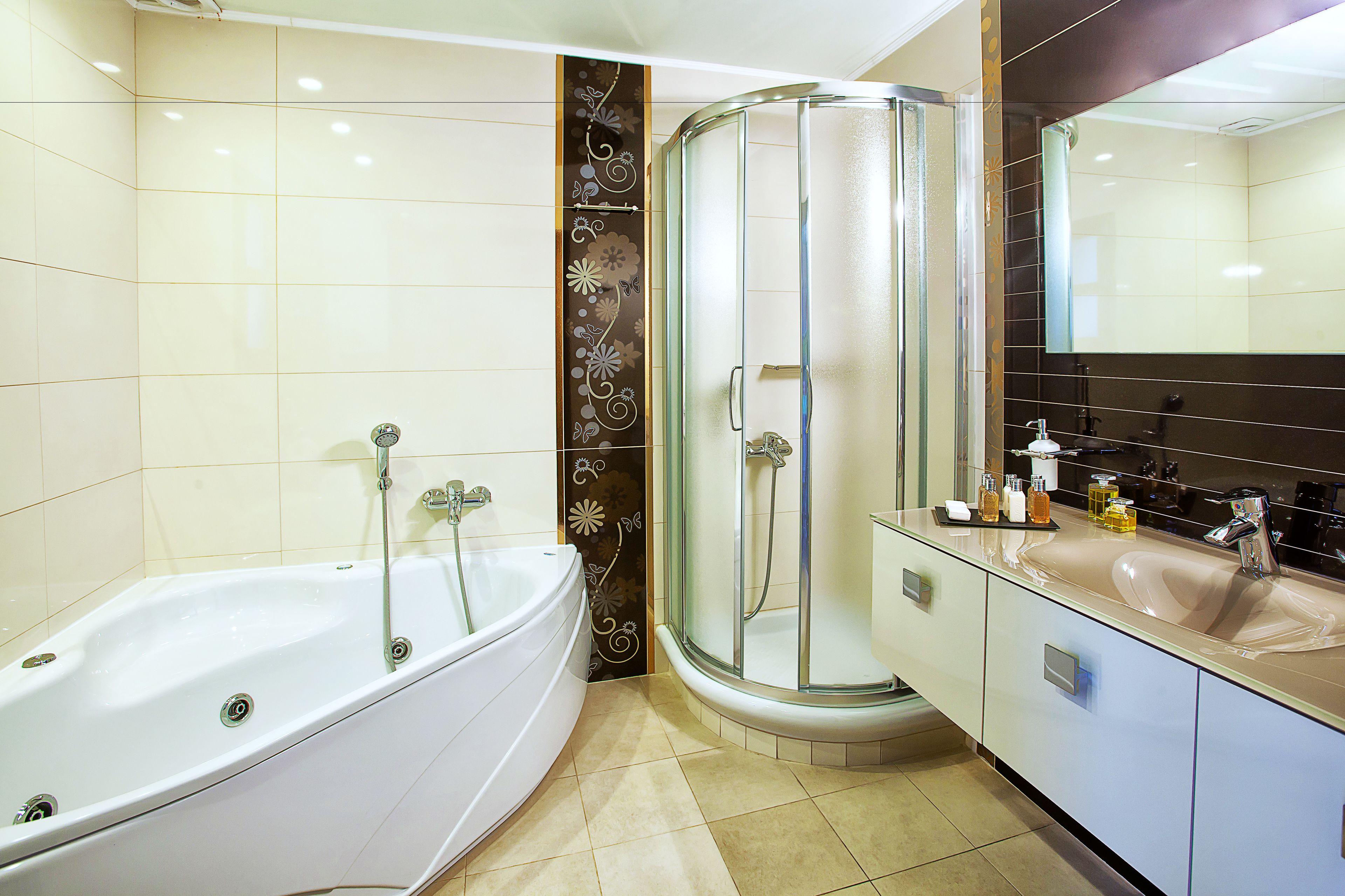 Un baño moderno con una bañera blanca, ducha con mampara de vidrio y tocador con un espejo grande.