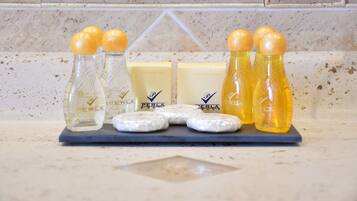 A bathroom counter with various toiletries including bottles and shower caps.