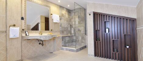 A modern bathroom with a large mirror, a sink, and a shower area.