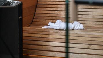 Uma sauna com banco de madeira e aquecedor preto.