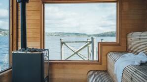 A cabin with a large window offering a view of a dock and water. - Hällsnäs (Mölnlycke)