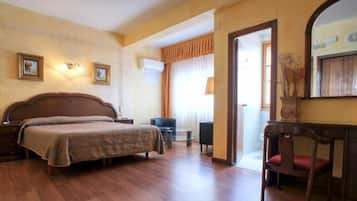 Ein Hotelzimmer mit einem großen Bett, einem Schreibtisch, einem Stuhl und einem Spiegel.