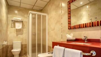 A modern bathroom with a glass shower enclosure, a toilet, and a red sink with a mirror above it.