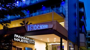 A modern hotel with a prominent neon sign, multiple floors, and a well-lit entrance. - Panama Majestic (Rimini)