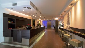 A modern hotel lobby with a reception desk, bar area, and seating. - Panama Majestic (Rimini)