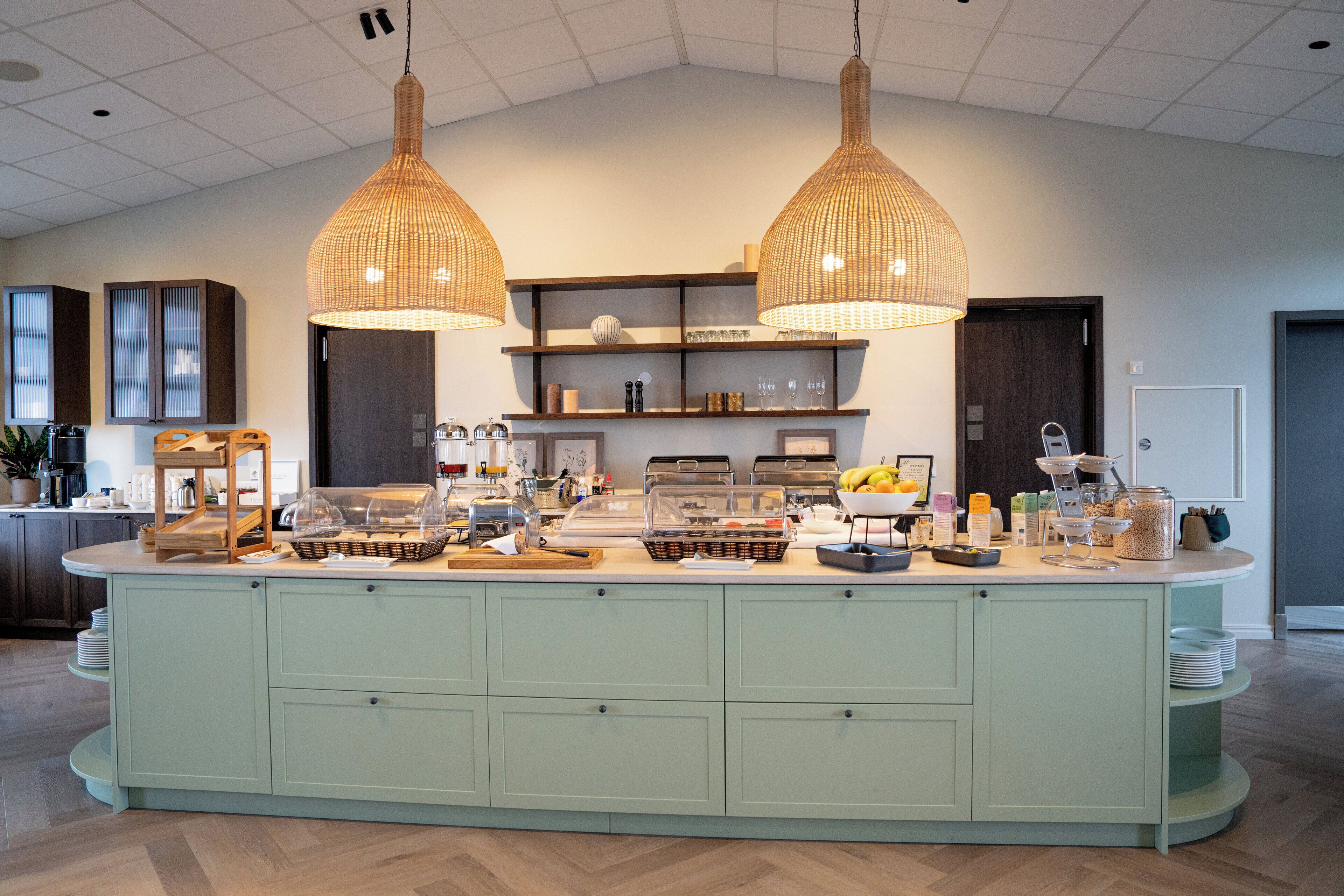 Une cuisine spacieuse dotée d’un îlot central, de luminaires suspendus et d’une variété d’appareils et d’ustensiles de cuisine.