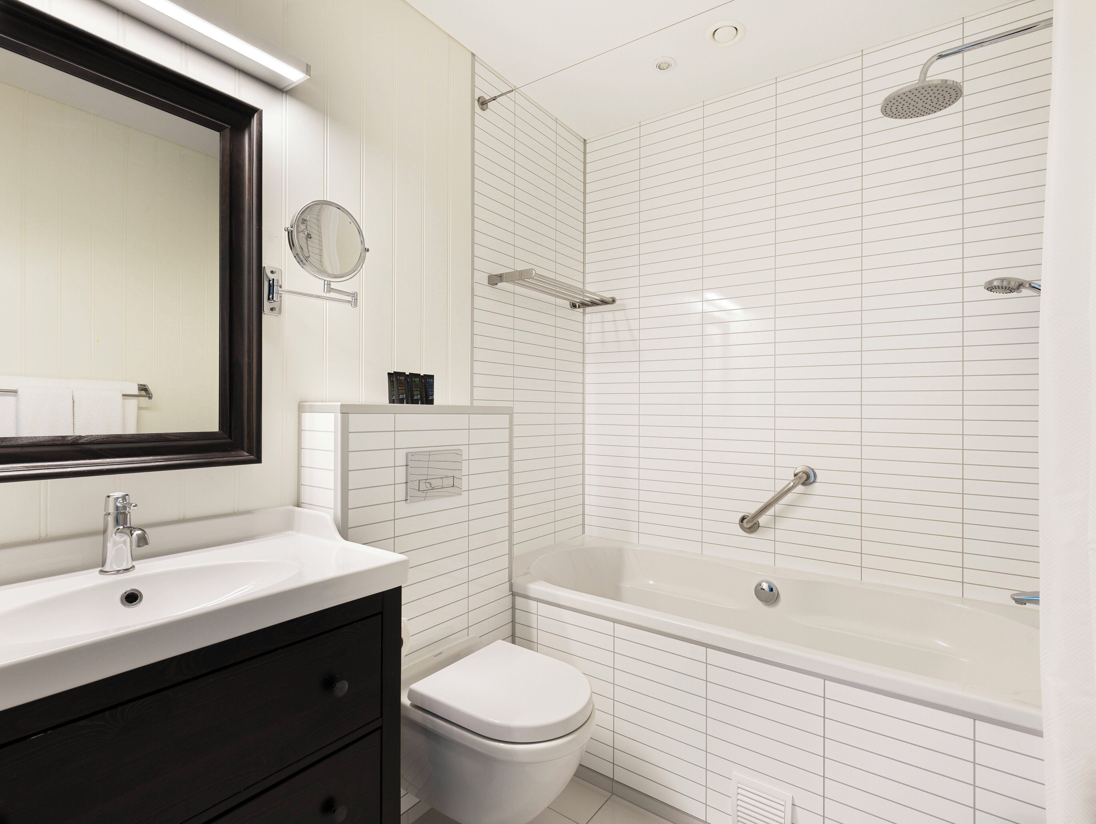 A modern bathroom with a white sink, a toilet, and a bathtub.