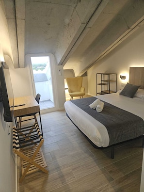 A compact room with a bed, a chair, a desk, and a small table. - Puerta de la Serrania (Lliria)
