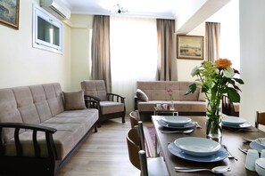 Appartement Deluxe, 2 chambres, rez-de-chaussée | Coin séjour | Télévision de 82 pouces avec chaînes par satellite, lecteur de DVD