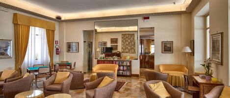 A spacious living room with multiple seating areas, a fireplace, and a bookshelf.