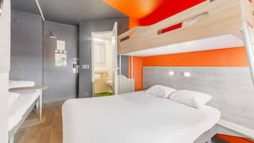 A modern hotel room with a bunk bed, a desk, and a bathroom visible through an open door.