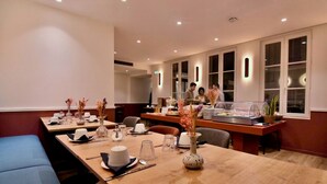 Un comedor de hotel con mesas dispuestas para comidas, un bufé y una zona de estar.