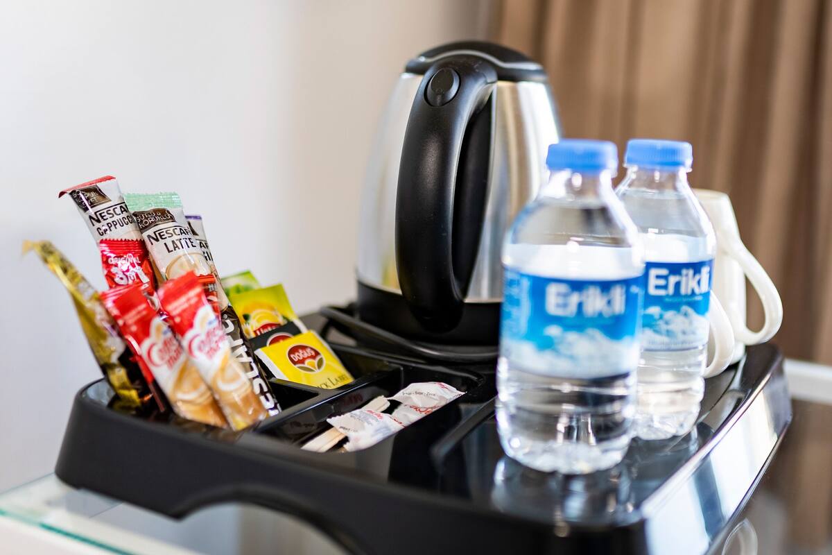 A coffee machine with various coffee pods and two bottles of water.