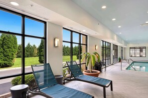 A poolside area with lounge chairs, a potted plant, and a view of the pool. - Hampton Inn Milford (Milford)