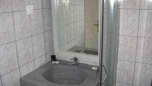A bathroom with a large bathtub, a sink, and a mirror. - Anemos Studios (Andros)