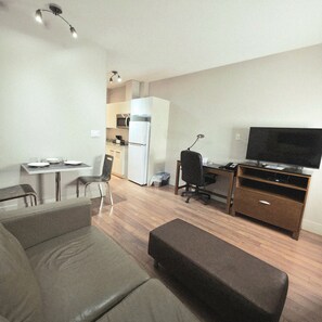 Uma sala de estar moderna com sofá, pufê e uma área de jantar com mesa e cadeiras.