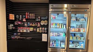 Een automatenruimte met snacks en drankjes, en een bord met de tekst 'Geen contante betalingen'.