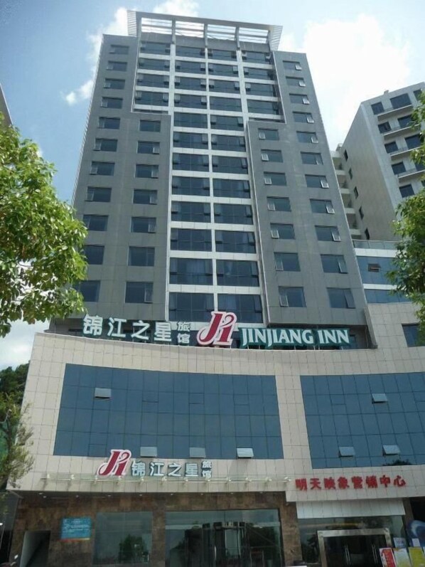 A tall building with multiple floors, featuring signage for JINJIANG INN and other establishments.
