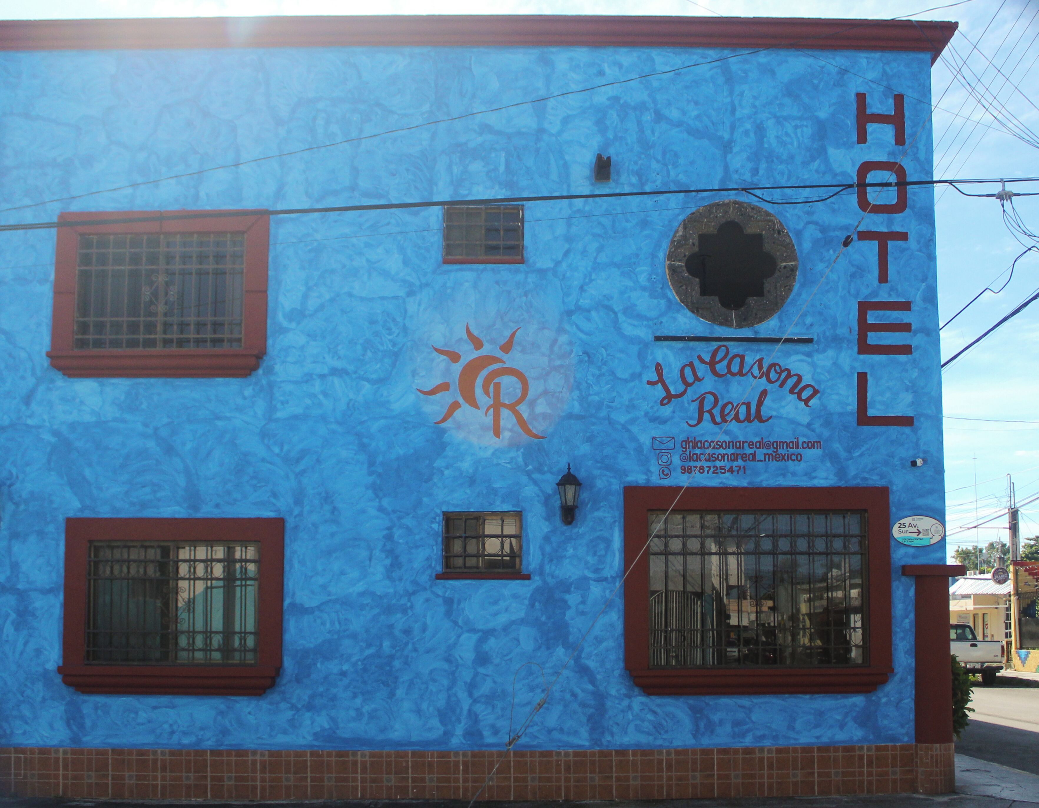 Um edifício com fachada azul, um símbolo de sol e o texto "La Laasonal Real Hotel".