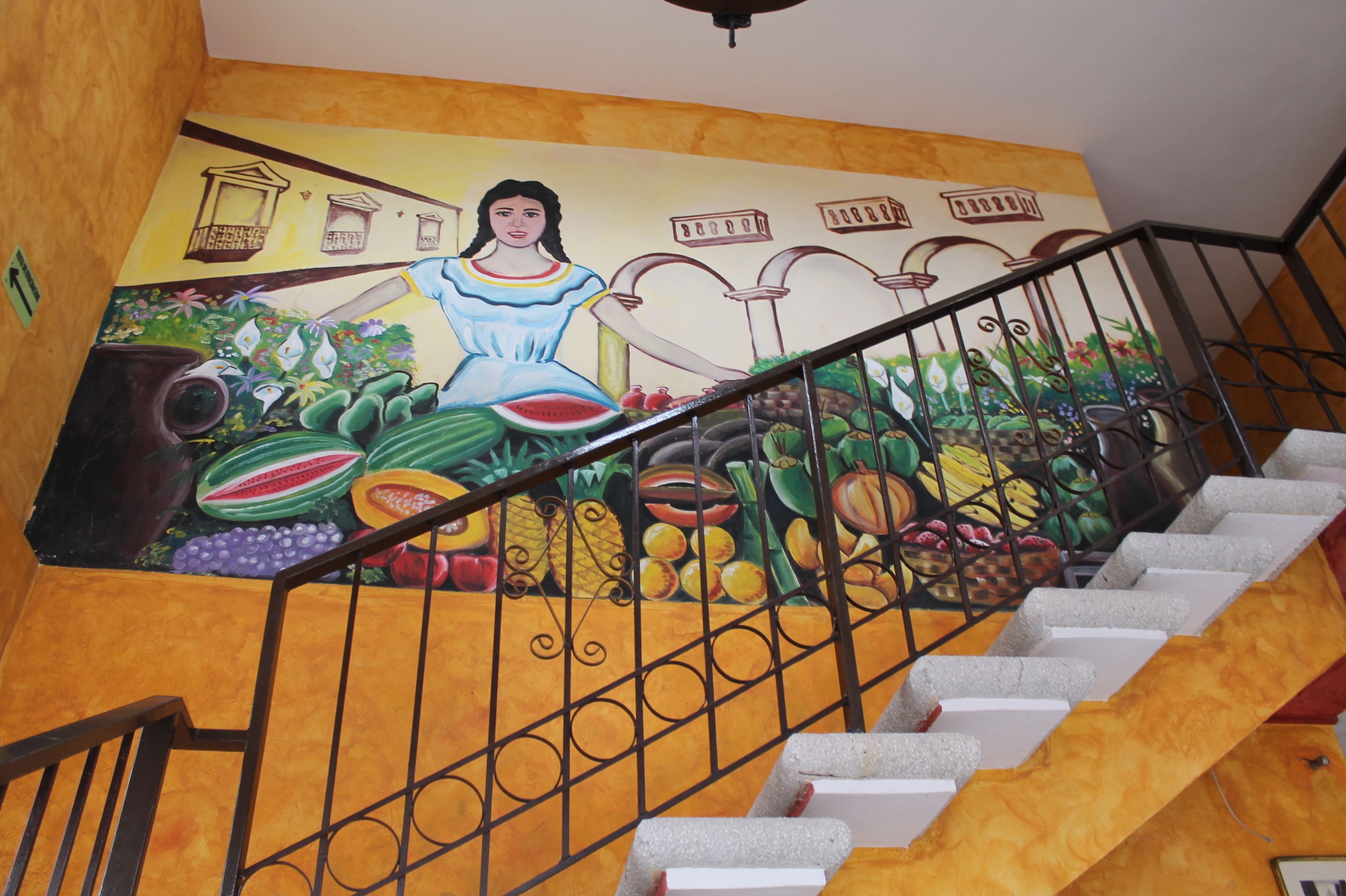 A staircase with a mural featuring a woman and various fruits.