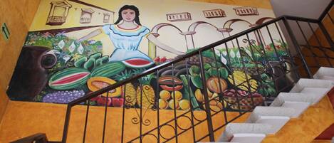 A staircase with a mural featuring a woman and various fruits.