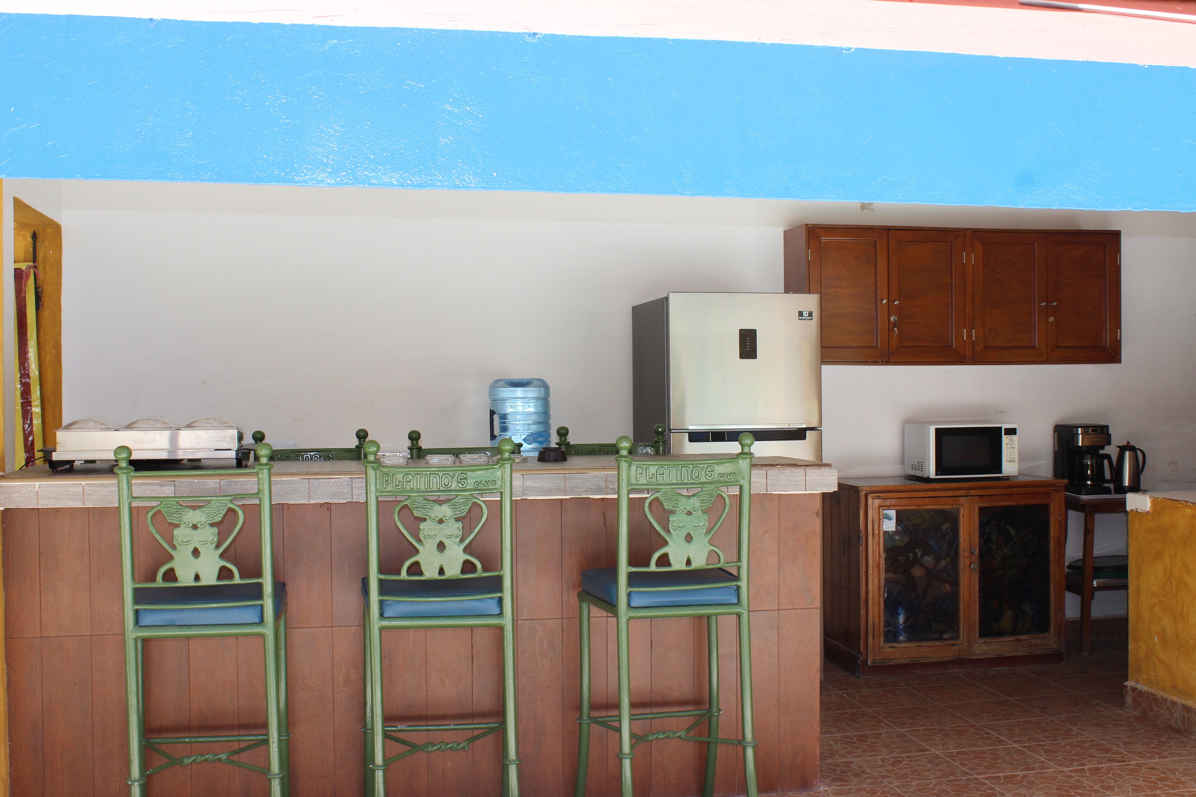 A kitchen with wooden cabinets, a microwave, a coffee maker, and a water dispenser.