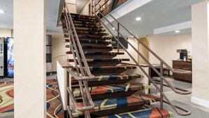 A staircase with metal railings and carpeted steps.