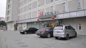 A building with a sign that reads "Jiang Jiang Star". There are three cars parked in front of the building. - Jinjiang Inn Shenzhen Airport (Shenzhen)