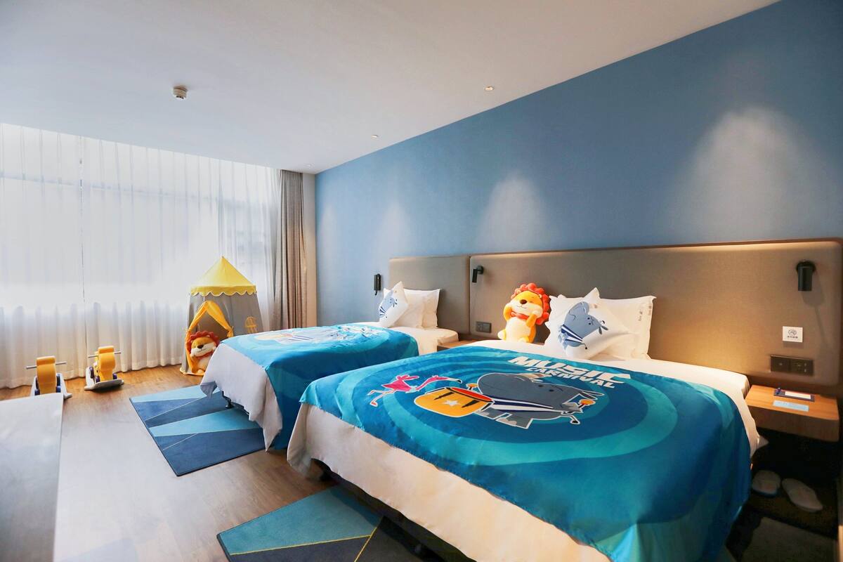 Ein Hotelzimmer mit zwei Betten, einem Zelt und einem Löwen-Plüschtier.