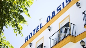 A hotel facade with the name "HOTEL OASIS" prominently displayed. - Hotel Oasis (Conil de la Frontera)