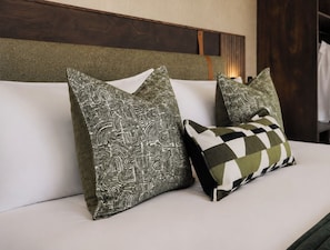 A bed with two pillows, one with a geometric pattern and another with a checkered design. - Tshukudu Game Lodge (Hoedspruit)
