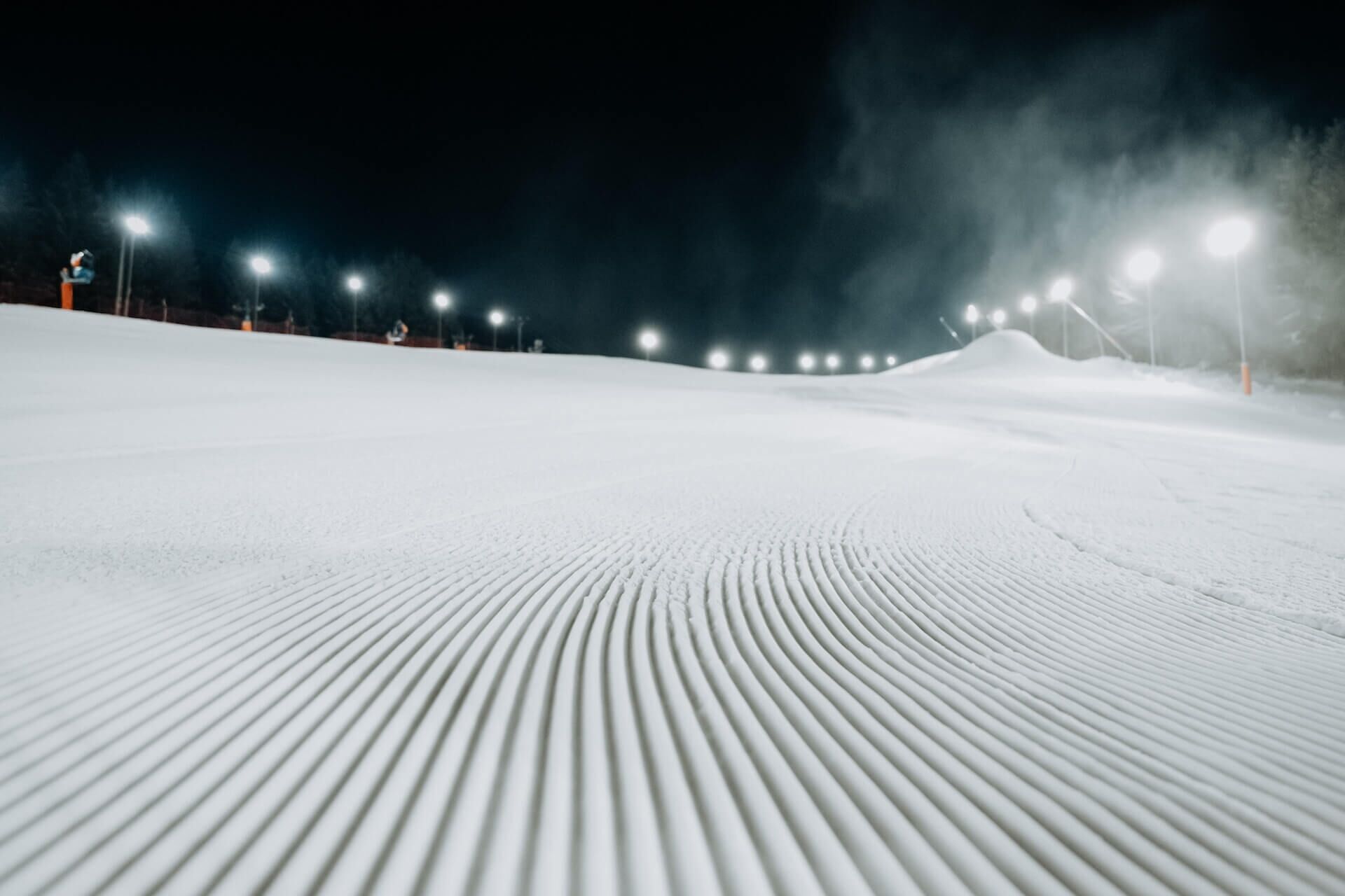 Encosta coberta de neve com uma série de luzes igualmente espaçadas ao longo da borda superior.