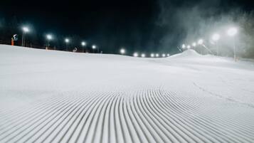 Encosta coberta de neve com uma série de luzes igualmente espaçadas ao longo da borda superior.