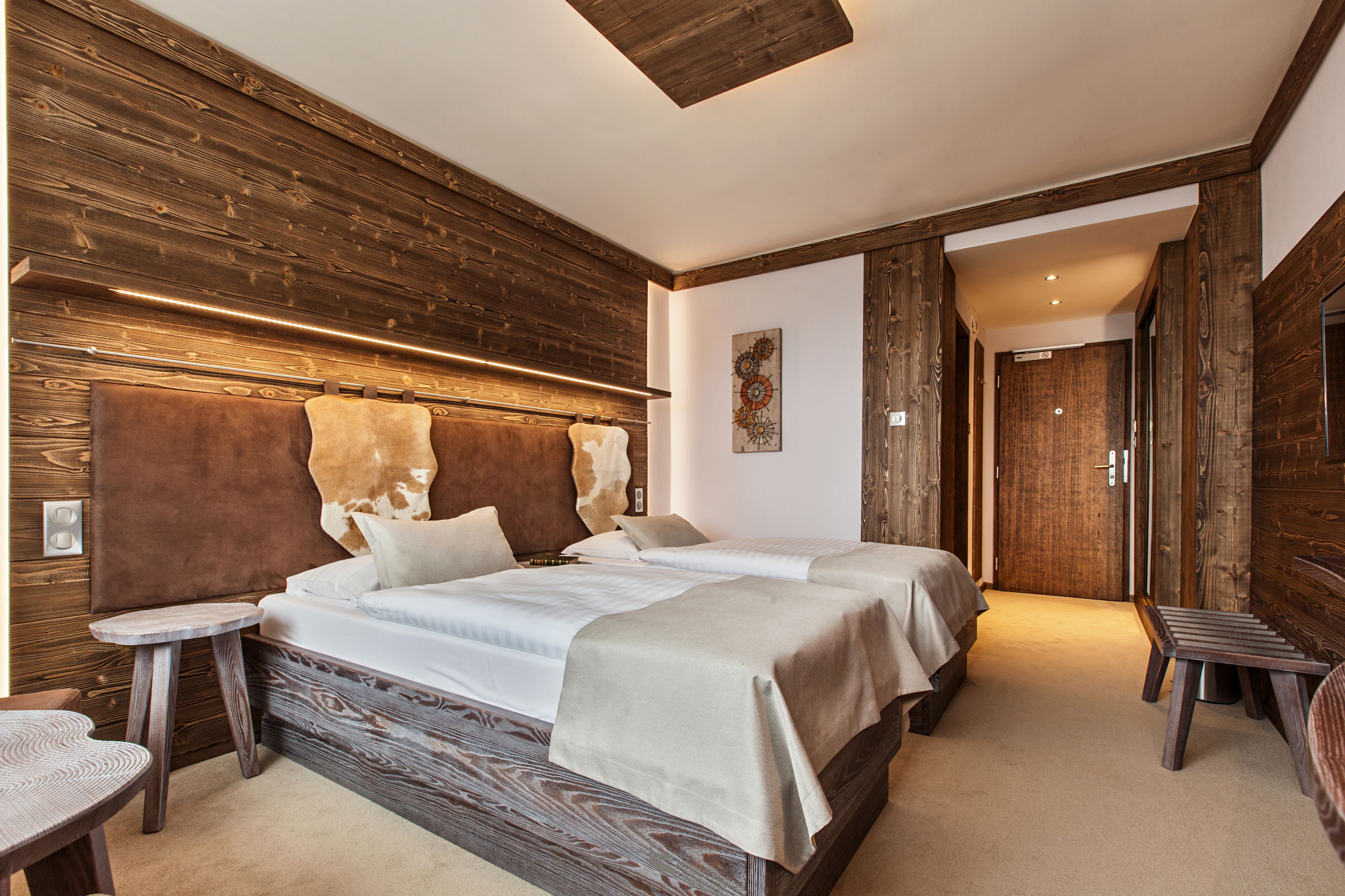 Een kamer met een groot bed, twee nachtkastjes en een zithoekje.