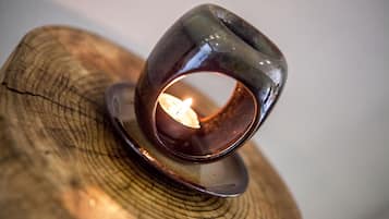 A candle holder with a lit candle on a wooden surface.
