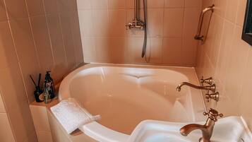 Een badkamer met een bad, wastafel en douche.