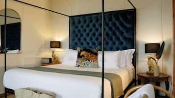 Classic elegance defines this inviting room, featuring a four-poster bed with a tufted headboard and a comfortable seating area.