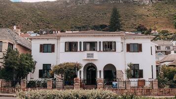 A white building with a tiled roof, arched entrance, and stone pillars.