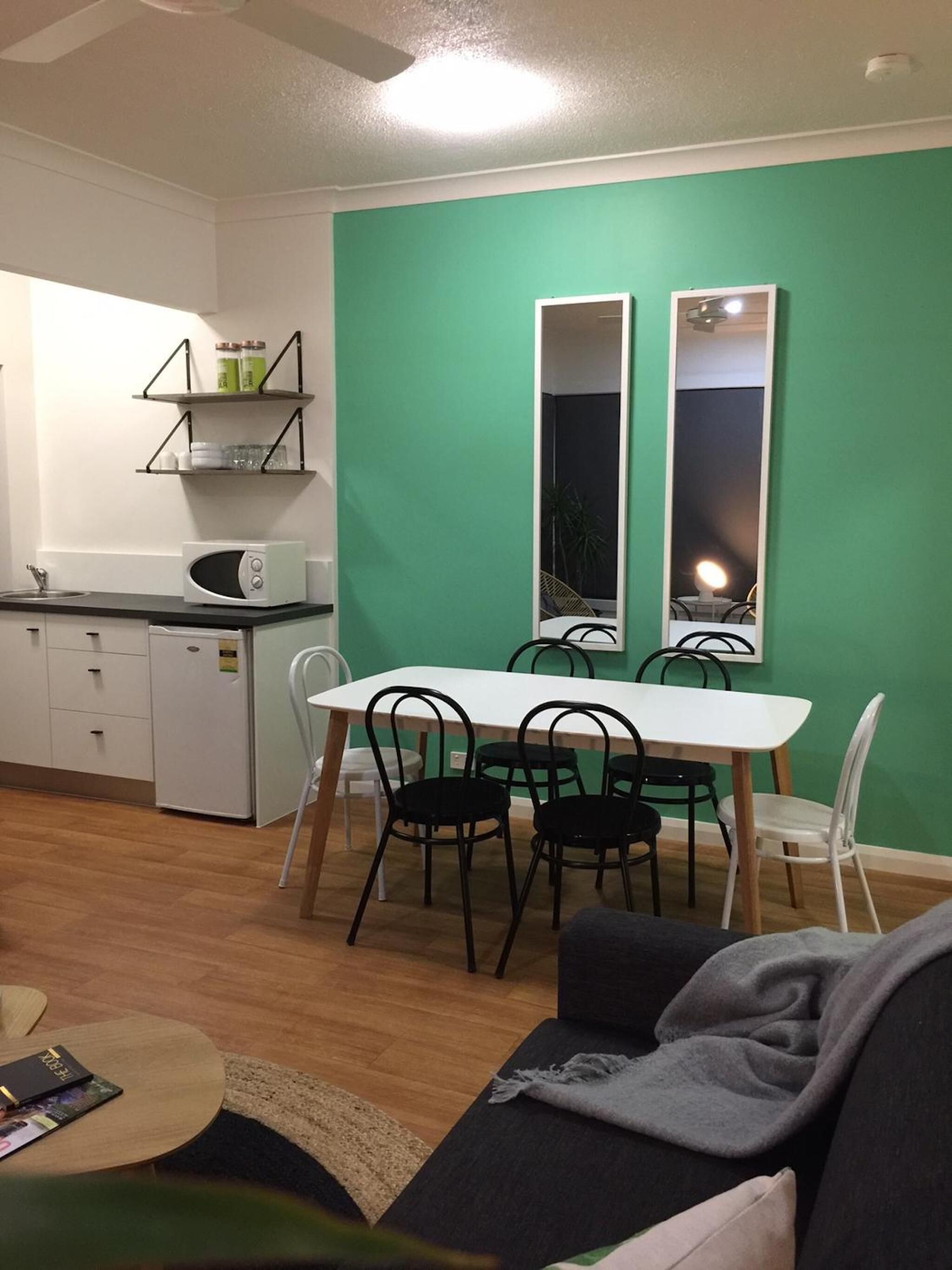 Un espacio habitable pequeño con kitchenette, una mesa de comedor con sillas y un sofá.