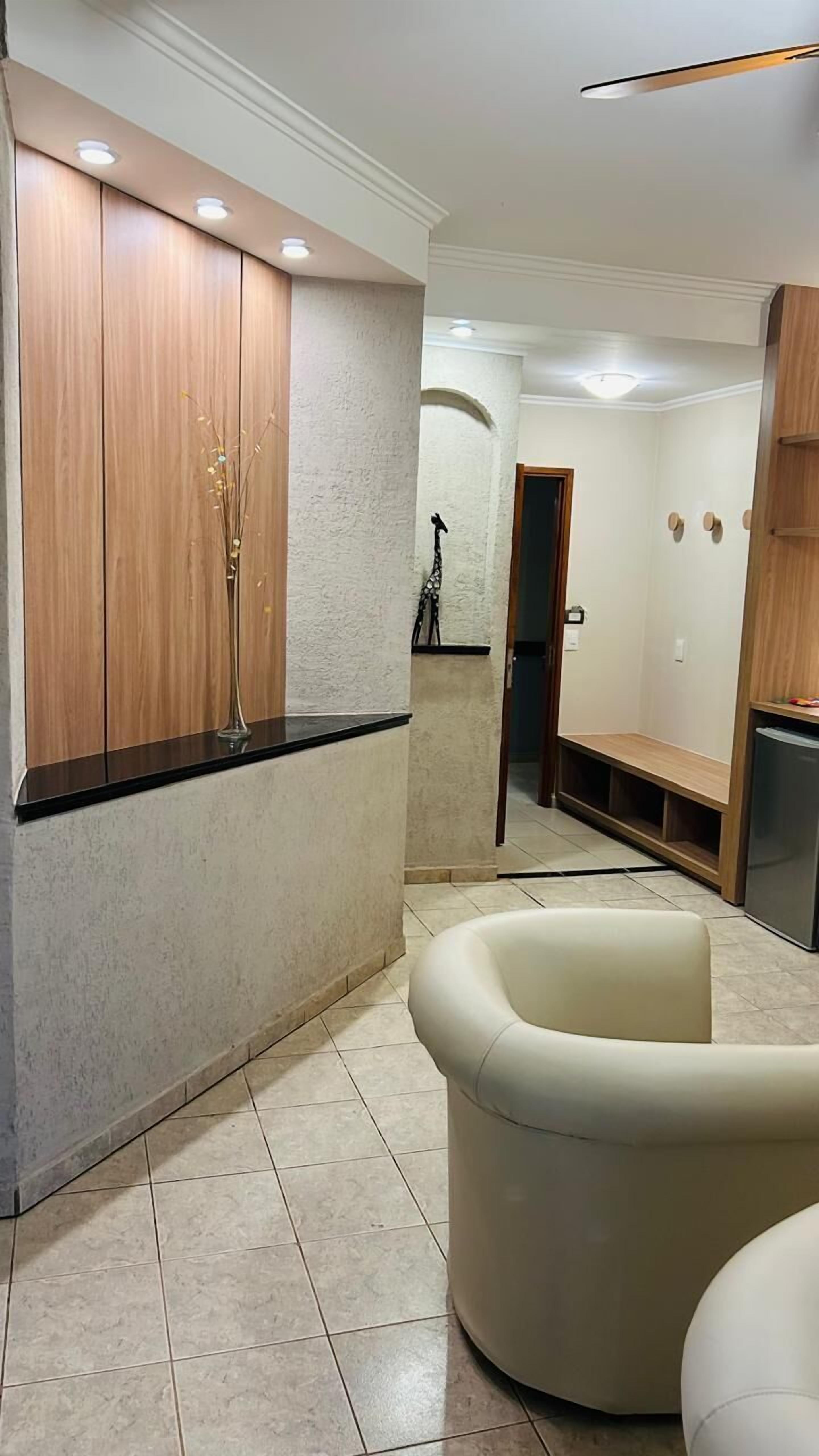 Un interior moderno con un armario de madera, un banco blanco y un sillón blanco.