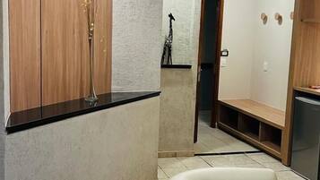 Un interior moderno con un armario de madera, un banco blanco y un sillón blanco.