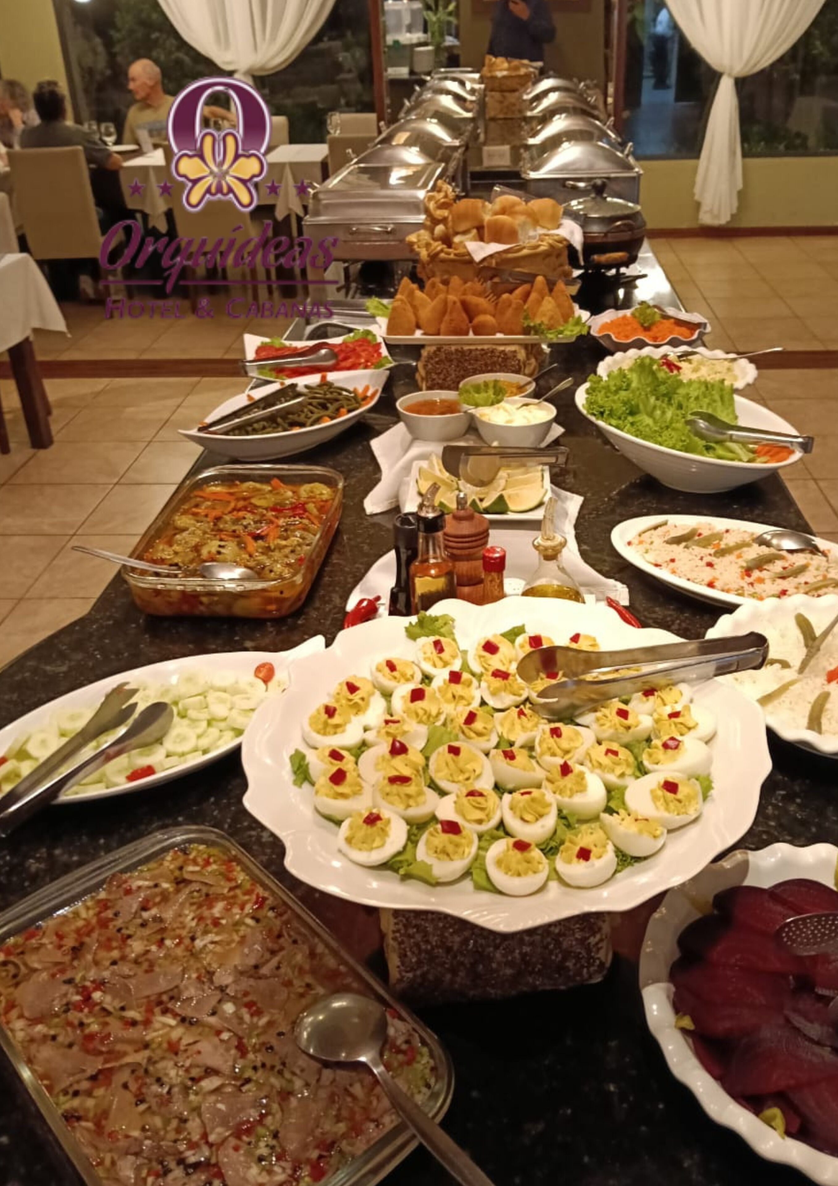 En buffet med forskellige retter, herunder salater, appetitvækkere og en stor anretning med fyldte æg.