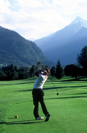 A person playing golf on a course with mountains in the background. - Comfort Hotel Garni Landhaus Gitti (Zell am See)