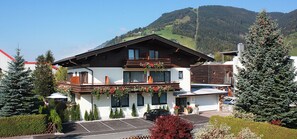 Un immeuble à deux étages doté d’un balcon, d’un parking et surplombant un paysage montagneux.