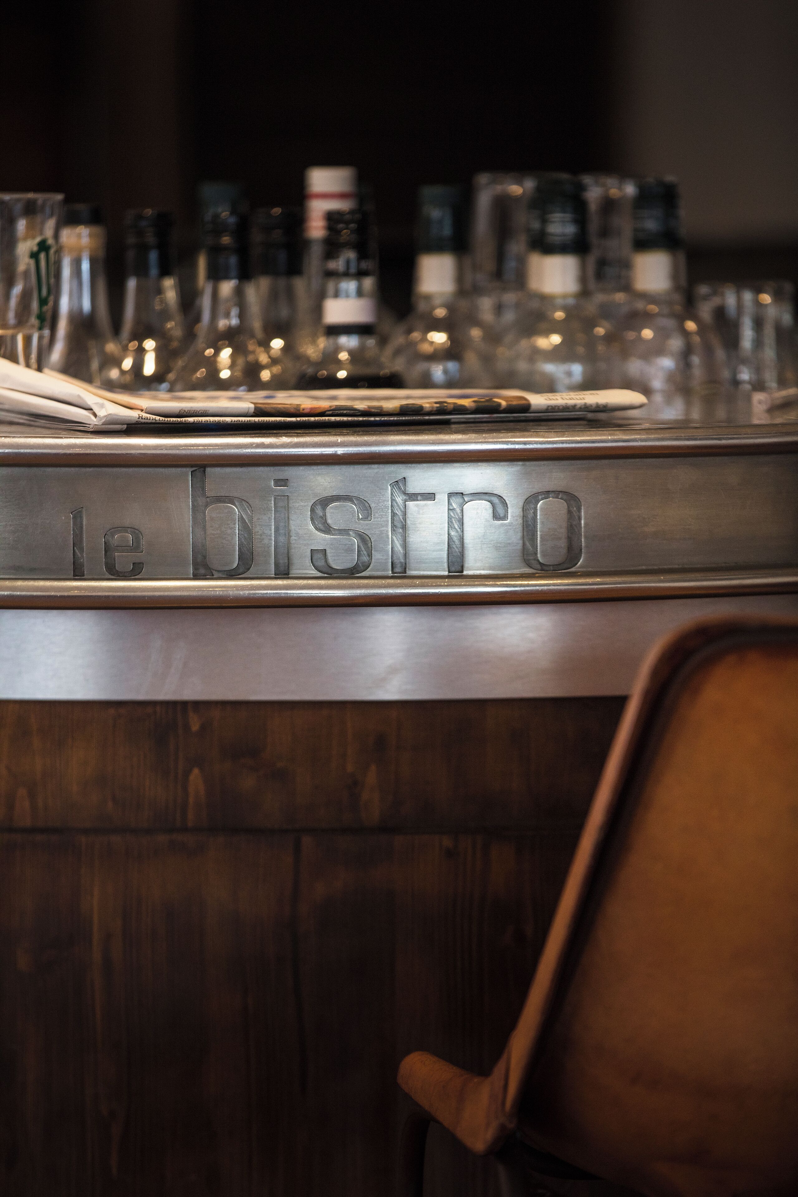 A bar area with a sign reading "le bistro" and various bottles and glasses on the counter.