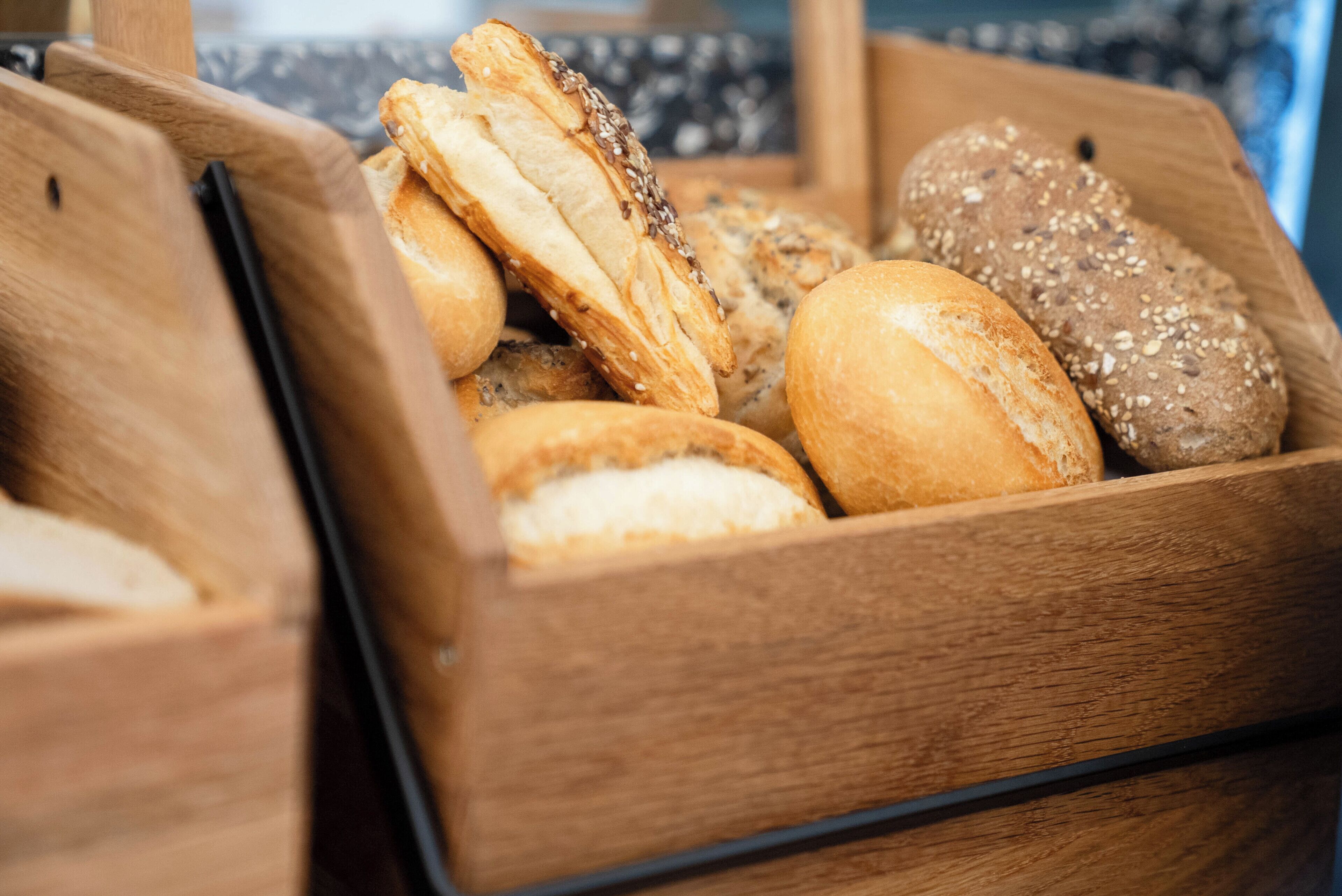 Una caja de madera con diferentes tipos de pan.