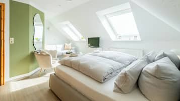 Camera da letto moderna con letto a soppalco, lucernari, un grande specchio e un piccolo angolo studio.