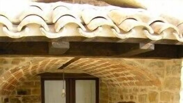 A stone building with a tiled roof, a wooden door, and a small entrance area. - Azienda Agrituristica Colle San Giorgio (Castiglione Messer Raimondo)