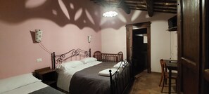 Un dormitorio con cama, mesita de noche y escritorio con silla.