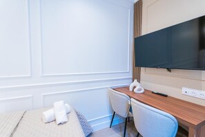 Escritorio, cortinas blackout y tabla de planchar con plancha 